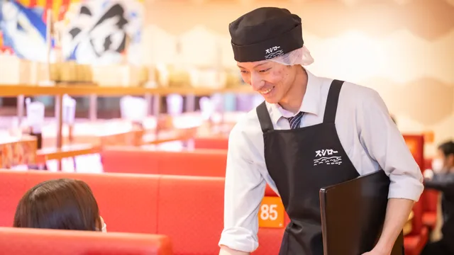 お客さまを席へご案内するホールのスタッフ